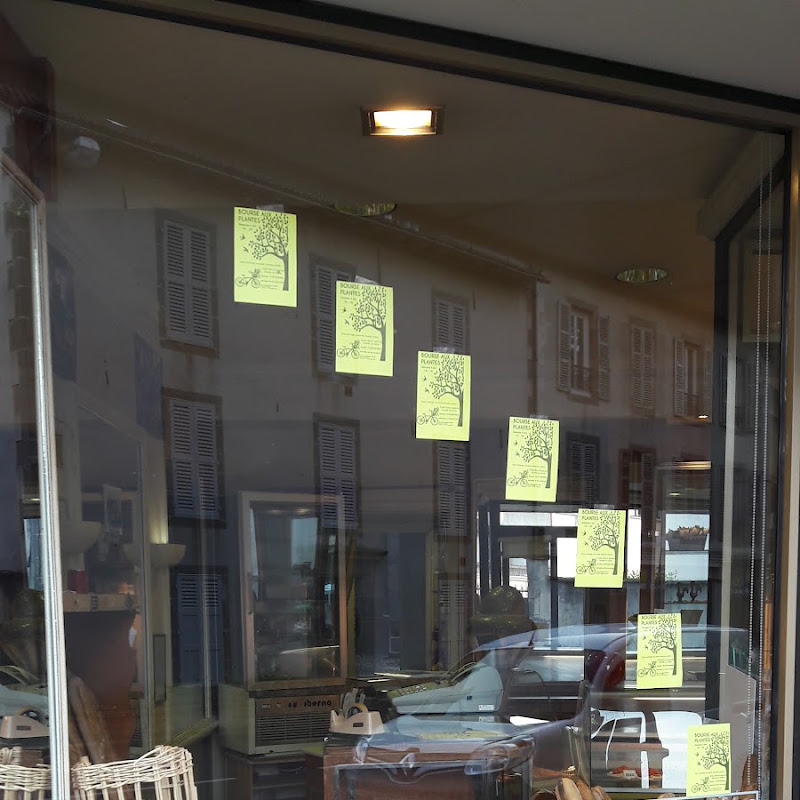 La devanture vitrée de la boulangerie, affiches jaunes et reflets de la rue